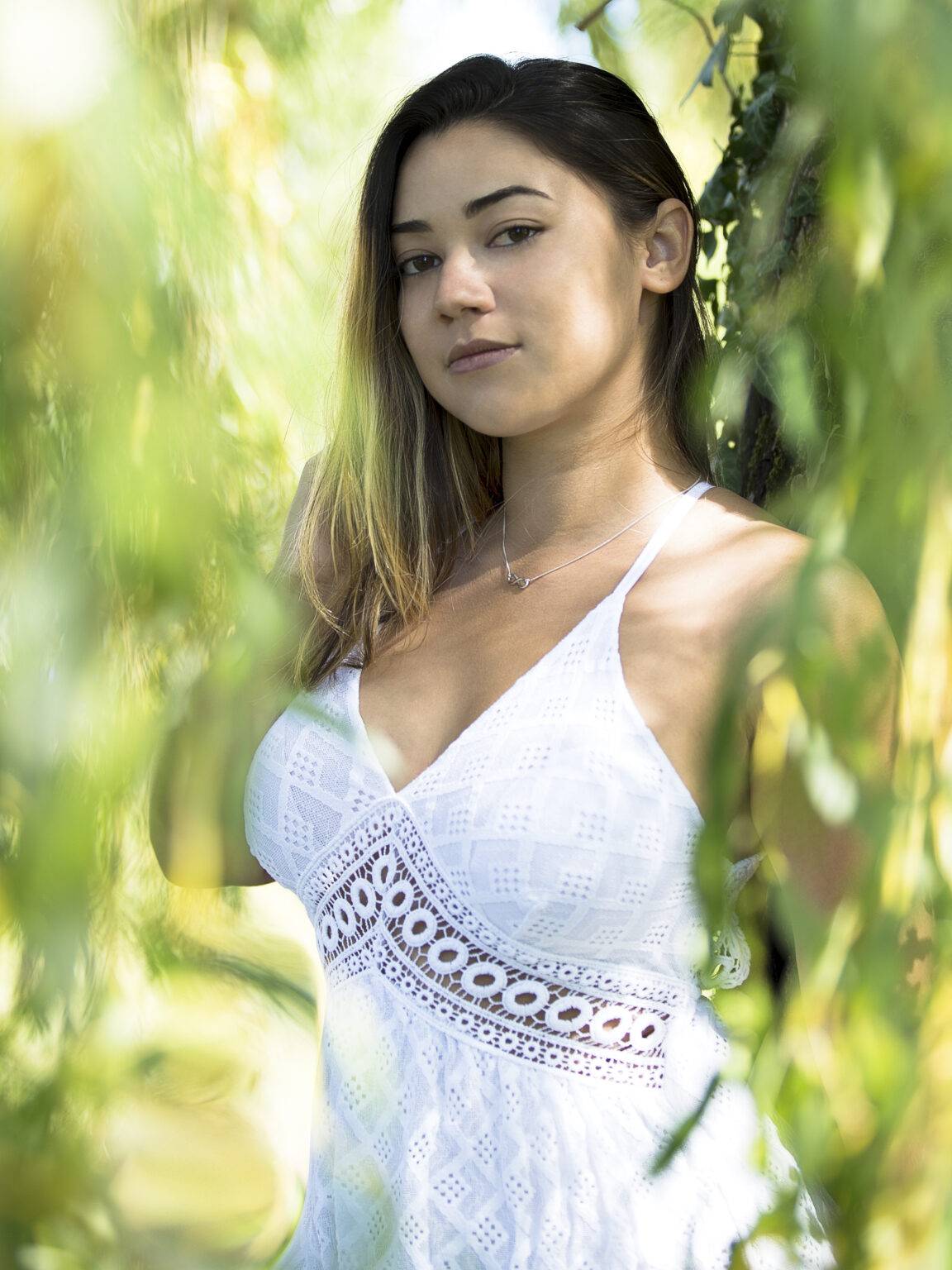 photo jeune femme a travers des feuilles