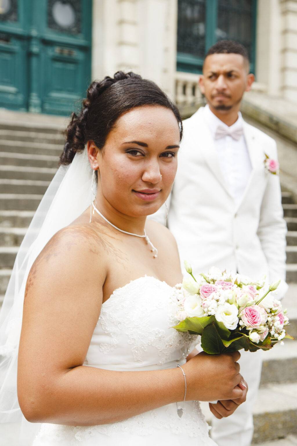 photo de mariage couple de mariée habillé en blanc sur les marches d'un escalier