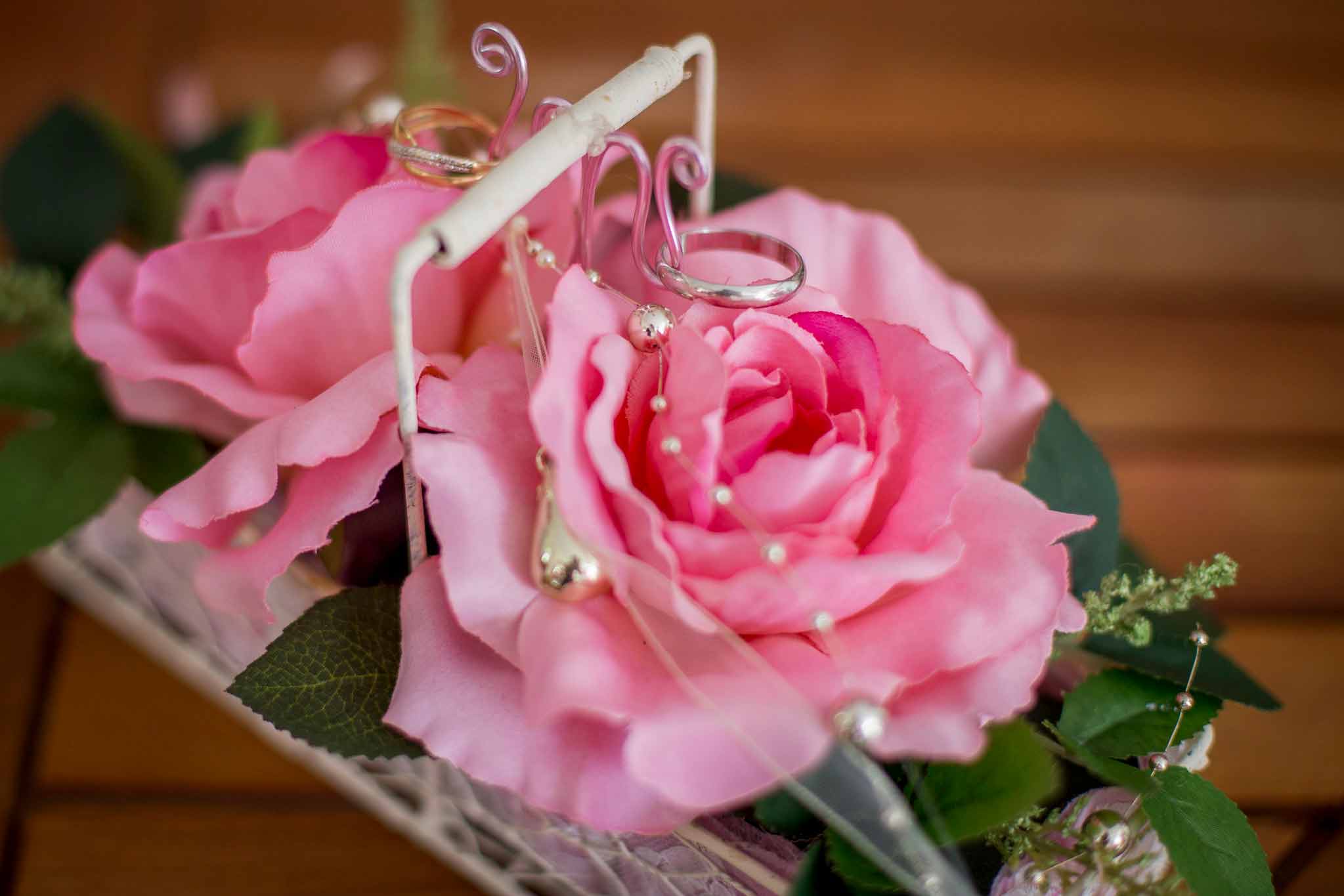 Bouquin de mariage rose avec deux alliances des mariés